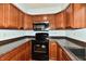 Galley kitchen with dark countertops and stainless steel appliances at 7922 S Sherman Dr, Indianapolis, IN 46237