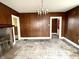 Empty living room with wood paneling, hardwood floors, and a fireplace at 310 S Pleasant St, Edinburgh, IN 46124