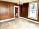Empty living room featuring wood paneling, hardwood floors, and large window at 310 S Pleasant St, Edinburgh, IN 46124