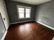 Simple bedroom with hardwood floors and gray walls at 3435 Carrollton Ave, Indianapolis, IN 46205