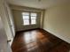 Simple bedroom with hardwood floors and a window at 3435 Carrollton Ave, Indianapolis, IN 46205