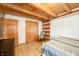 Simple bedroom with log cabin walls, hardwood floors, and double doors at 6465 Mt Moriah Rd, Nineveh, IN 46164