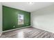 Spacious bedroom with green accent wall and wood-look flooring at 1782 N Clearwater Dr, Greenfield, IN 46140