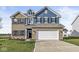 Two-story home with brick and blue siding, a white garage door, and a landscaped lawn at 1782 N Clearwater Dr, Greenfield, IN 46140