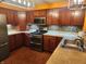 L-shaped kitchen with dark wood cabinets, stainless steel appliances and tile backsplash at 4835 Franklin Villas Dr, Indianapolis, IN 46237