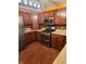 L-shaped kitchen with dark wood cabinets and stainless steel appliances at 4835 Franklin Villas Dr, Indianapolis, IN 46237