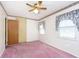 Bedroom with pink carpet, ceiling fan, and double doors at 8530 Meadowlark Dr, Indianapolis, IN 46226