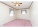 Bedroom with pink carpet, ceiling fan, and floral curtains at 8530 Meadowlark Dr, Indianapolis, IN 46226