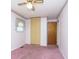 Bedroom with pink carpet, ceiling fan, and double doors at 8530 Meadowlark Dr, Indianapolis, IN 46226