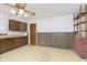 Retro kitchen features wood cabinets, tile floor, and a brick accent wall at 8530 Meadowlark Dr, Indianapolis, IN 46226