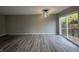 Spacious living room featuring gray walls and wood-look flooring, with access to a deck at 3518 Birchfield Pl, Indianapolis, IN 46268