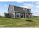 Rear view of a two story house with gray siding, showcasing a patio and landscaping at 4973 Amber Crest Dr, Brownsburg, IN 46112