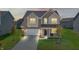 Two-story home with illuminated windows at dusk, showcasing curb appeal at 10797 Walden Ln, Brownsburg, IN 46112