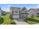 Two-story house with gray and beige siding, a white garage door, and a driveway at 10797 Walden Ln, Brownsburg, IN 46112