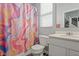 Clean bathroom with a white vanity, toilet, and colorful shower curtain at 10797 Walden Ln, Brownsburg, IN 46112