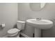 Clean bathroom with pedestal sink, toilet, and light gray walls at 10797 Walden Ln, Brownsburg, IN 46112