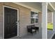 Brick front porch with a black front door and two wicker chairs at 10797 Walden Ln, Brownsburg, IN 46112