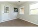 Sunroom featuring carpet, windows, and exterior access at 408 N Sherwood Dr, Muncie, IN 47304