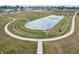 Aerial view of a community pond with a fountain and surrounding walking path at 243 Hunters Ridge Dr, Danville, IN 46122