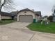 Beige one car garage with driveway and grassy yard at 4112 Eagle Cove E Dr, Indianapolis, IN 46254