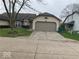 Tan house exterior with a two car garage and landscaping at 4112 Eagle Cove E Dr, Indianapolis, IN 46254