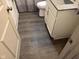 Bathroom with gray wood-look flooring, white vanity, and granite countertop at 4204 W Palomino Ct, Muncie, IN 47304