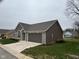 Side view of the house, showcasing the garage and stone accents at 4204 W Palomino Ct, Muncie, IN 47304