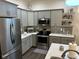 Modern kitchen with gray cabinets, quartz countertops, and stainless steel appliances at 4204 W Palomino Ct, Muncie, IN 47304