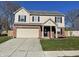 Two-story house with beige siding, brick accents, and a two-car garage at 7530 Redcliff Rd, Indianapolis, IN 46256