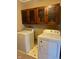 Bright laundry room, featuring washer, dryer, and upper cabinets at 2628 Walker Ave, Indianapolis, IN 46203