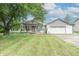 Ranch home with gray and white exterior, covered porch, and attached two-car garage at 500 Hickory Dr, Greenfield, IN 46140