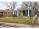 Gray brick house with yellow door, covered porch, and small front yard at 5114 Hillside Ave, Indianapolis, IN 46205
