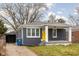 Gray brick house with yellow door, covered porch, and detached shed at 5114 Hillside Ave, Indianapolis, IN 46205
