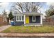 Gray brick house with yellow door, covered porch, and small front yard at 5114 Hillside Ave, Indianapolis, IN 46205
