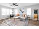 Spacious living room with gray sectional sofa, hardwood floors, and large windows at 5114 Hillside Ave, Indianapolis, IN 46205