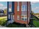 Front view of a modern townhome with brick and blue siding at 2151 N College Ave, Indianapolis, IN 46202