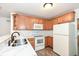 Modern kitchen with oak cabinets, white appliances, and a breakfast bar at 11736 Grazing Ln, Indianapolis, IN 46239