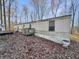 Single-wide manufactured home with wooden deck and surrounding trees at 4355 E Streacher Rd, Bloomington, IN 47408