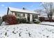 Snow-covered ranch home with dark trim and landscaping at 50 Mckinley St, Shelbyville, IN 46176