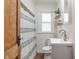 Clean bathroom with white vanity, shower, and wood door at 5254 W 14Th St, Indianapolis, IN 46224