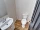 Simple bathroom with white vanity, toilet and dark door at 1135 Fairfield Ave, Indianapolis, IN 46205