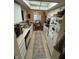 Galley kitchen with white cabinetry, tile flooring, and view to dining area at 3250 Valley Farms Way, Indianapolis, IN 46214