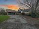 Stone house with a three-car garage and landscaped lawn, at sunset at 720 E 400 N, Anderson, IN 46012