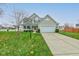 Two-story house with beige siding, a white two-car garage, and a well-maintained lawn at 7230 Rodney Pl, Noblesville, IN 46062