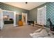 Bedroom with floral wallpaper, wooden dresser, and access to other rooms at 1605 E Thompson Rd, Indianapolis, IN 46227
