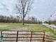 Red metal gate opens to a grassy field at 2750 N County Road 1000 E, Indianapolis, IN 46234