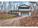 A charming two-story home with a large screened porch and attached garage, set on a hillside at 13832 W Old Nashville Rd, Columbus, IN 47201