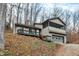 Two-story house with screened porch, deck, and attached garage, nestled in a wooded setting at 13832 W Old Nashville Rd, Columbus, IN 47201