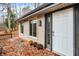Inviting front entrance with a white door and a wooden deck, surrounded by autumn leaves at 13832 W Old Nashville Rd, Columbus, IN 47201