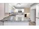 Galley kitchen with white cabinets, granite countertops, and stainless steel appliances at 13832 W Old Nashville Rd, Columbus, IN 47201